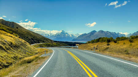 Mount Cook Road alongside Lake Pukaki with the snow covered Southern alps and Aoraki in the distanceの写真素材