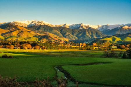 Early morning sun warming the snow capped Tararua mountain range  after some overnight snow on the peaksの写真素材