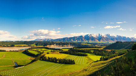 Near the village of  Windwhistle looking over agricultural farming fields and the Rakaia Gorge towards Mt Hutt with a slight dusting of snow on the mountain peakの写真素材