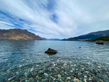 The small rocks under the surface of the water at the lakeshore edge of Lake Wakatipuの写真素材