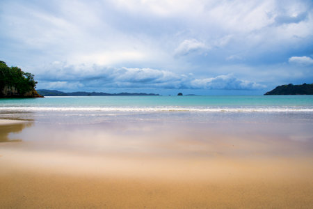 The beautiful golden sandy beach and clear blue water in the ocean in the bayの写真素材