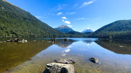 A remote isolated lake in the wilderness of Mount Aspiring National Park accessible only through a walk through a lush native forest after a  long drive on a gravel roadの写真素材