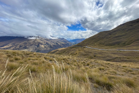Looking down from the top of the Crown Range road over the agricultural land in the Queenstown valley with the town in the distanceの写真素材
