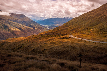 Looking down from the top of the Crown Range road over the agricultural land in the Queenstown valley with the town in the distanceの写真素材
