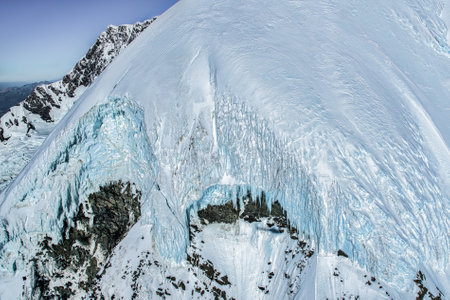 Flying  over the tallest snow covered peaks of the Southern alps in a helicopter with no glass windowsの写真素材