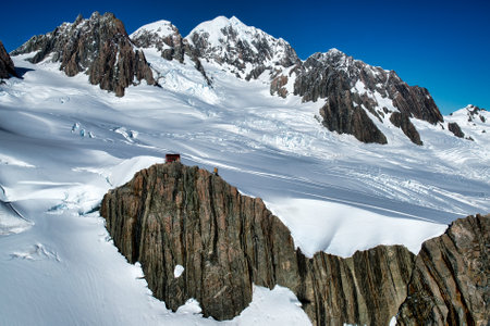 Flying  over the tallest snow covered peaks of the Southern alps in a helicopter with no glass windowsの写真素材