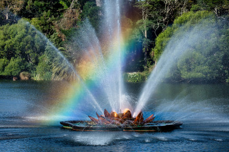 A rainbow caught in the mist and spray over the modern art fountain  in the central city lakeの写真素材