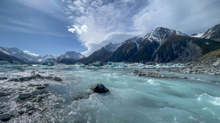 The Tasman river rushing out of  the alpine lake leaving behind lots of icebergs on the surface of...