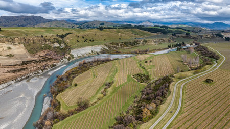 The blue water of the Awatere river flowing through agricultural farmland in a rural valleyの写真素材