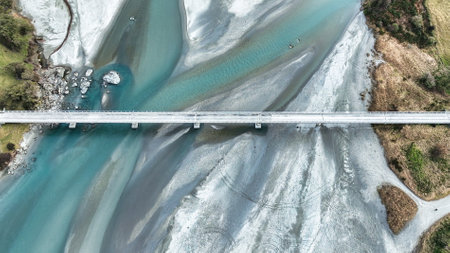 Aerial drone scenery of the braided Dart river flowing through a rural valley bordered by the Southern Alps mountains into Lake Wakatipu near Glenorchyの写真素材