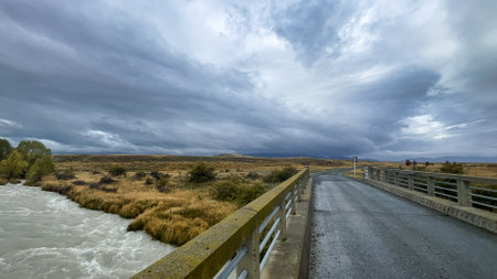Flooded stream on the winding narrow gravel road between Lake Tekapo and Lake Pukaki in rural agricultural landの写真素材