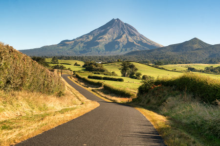 Country road winding its way through farming countryside heading to the volcanic mountain