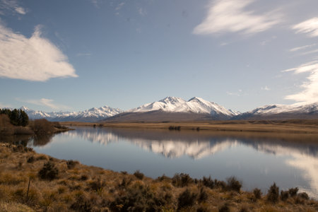 Grassy foreshore on the edge of Lake Clearwater beneath the southern alps in Hakatere conservation parkの写真素材