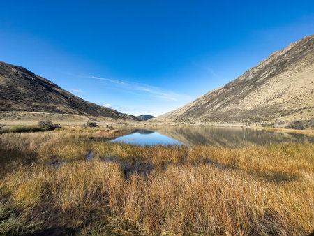 Remote alpine lake surrounded by mountain rangesの写真素材