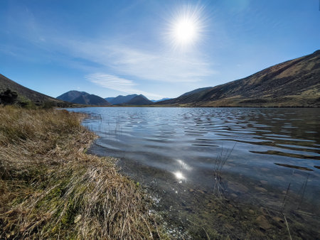 Remote alpine lake surrounded by mountain rangesの写真素材