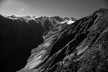 Black and white photo Flying over the southern alps mountain range snow covered peaks