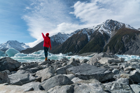 Woman standing on a rock in front of a glacierの写真素材