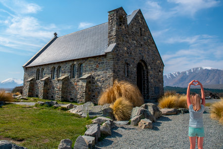 Woman making the heart symbol on the grounds of the Tekapo Chapelの写真素材