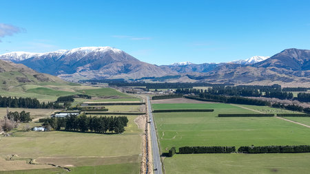 Aerial view of New Zealand alps and farmland in spring.