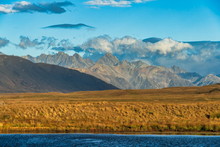Heading to the tall mountain range peaks on a windy dirt Road in conservation Parkの写真素材