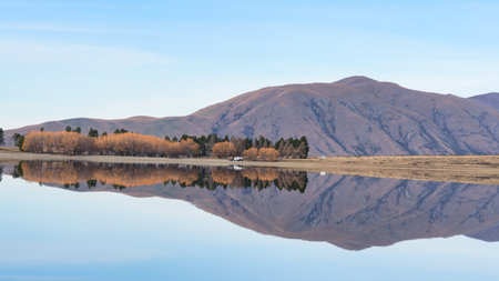 The mountains around Lake Camp reflected in the still alpine waterの写真素材