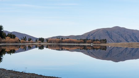 The mountains around Lake Camp reflected in the still alpine waterの写真素材