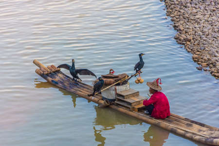 YANGSHUO, CHINA, 6 DECEMBER 2019: Cormorant fisherman on the Li River in Yangshuoのeditorial素材