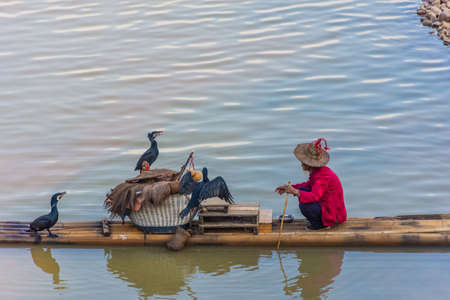 YANGSHUO, CHINA, 6 DECEMBER 2019: Cormorant fisherman on the Li River in Yangshuoのeditorial素材
