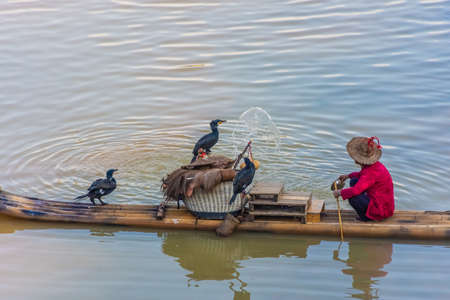 YANGSHUO, CHINA, 6 DECEMBER 2019: Cormorant fisherman on the Li River in Yangshuoのeditorial素材