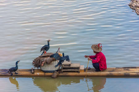 YANGSHUO, CHINA, 6 DECEMBER 2019: Cormorant fisherman on the Li River in Yangshuoのeditorial素材