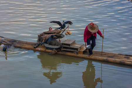 YANGSHUO, CHINA, 6 DECEMBER 2019: Cormorant fisherman on the Li River in Yangshuoのeditorial素材