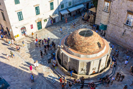 DUBROVNIK, CROATIA, AUGUST 13 2019: People walking around the old fountain in the ancient historic centerのeditorial素材
