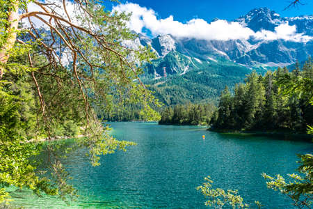 Faboulus landscape of Eibsee Lake with turquoise water in front of Zugspitze summit under sunlight....