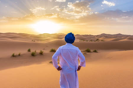 Young arabic man wearing traditional berber clothes in the Sahara Desert of Merzouga, Moroccoの写真素材