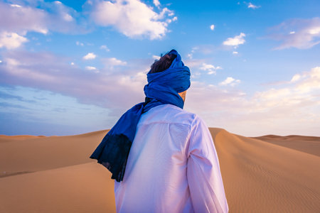 Young arabic man wearing traditional berber clothes in the Sahara Desert of Merzouga, Moroccoの写真素材