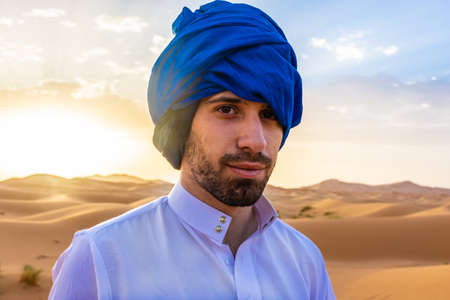 Young arabic man wearing traditional berber clothes in the Sahara Desert of Merzouga, Moroccoの写真素材