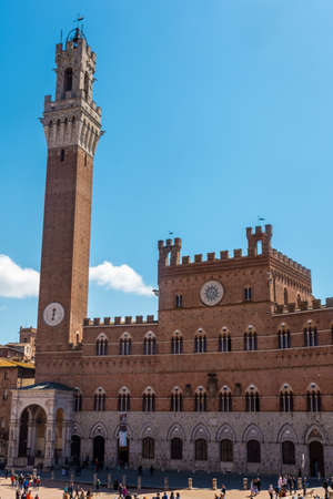Siena, Italy, 17 April 2022: tourists enjoy Piazza del Campo square and the town hall in Siena, Italy. The historic center of Siena has been declared by UNESCO a World Heritage Site.のeditorial素材