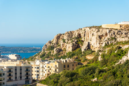 Houses built under a cliff in Mellieha, Maltaの写真素材