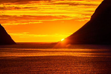 Incredible midnight sunset over the sea of Vik beach, Lofoten Islands, Norwayの写真素材