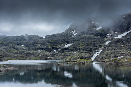 Reflection over a lake in moody vibe on the hike for Trolltunga, Norwayの写真素材