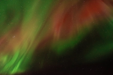 Amazing aurora borealis in the starry sky. Green and red northern lights in Icelandの写真素材