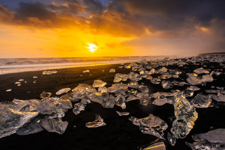 Amazing sunset over the Diamond Beach, volcanic black beach with icebergs from the Jokulsarlon...