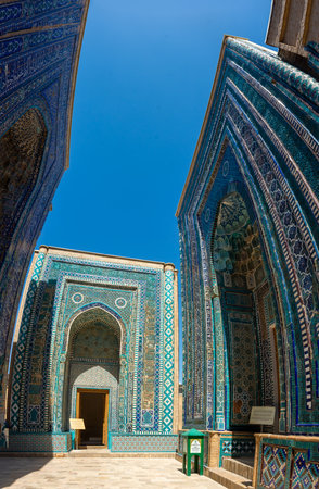 View of the Shah-i-Zinda Ensemble in Samarkand, Uzbekistan. Mausoleums decorated by blue tiles with designs. The necropolis is a popular tourist attraction of Central Asia. Translation: in the name of the almighty Allah who createsの写真素材