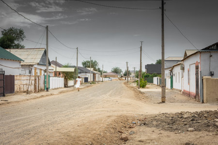 Moynaq, Uzbekistan, 16 August 2023: local woman walking the street of the poorest district of Moynaq, now in terrible conditions due to the death of the Aral Seaの写真素材