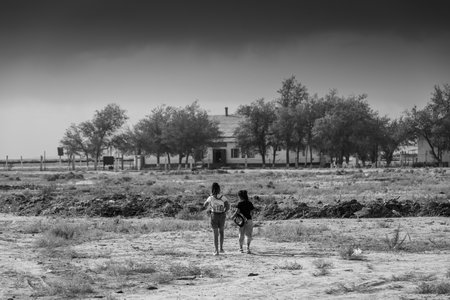 Karakalpakstan, Uzbekistan, 18 August 2023: The only two children of the village Qubla-Ustyurt going to school in the territory of the Aral Seaの写真素材