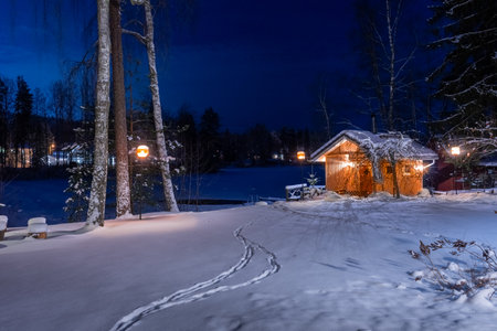 Lonely wooden cabin on the shore of a frozen lake. Snowy landscape at night in LempÃ¤Ã¤lÃ¤, Finlandの写真素材