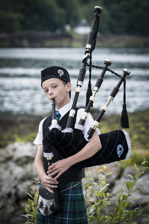 Scotland, UK - August, 7 - 2013 -Young man clad in a traditional scottish tartan playing the scottish bagpipeのeditorial素材