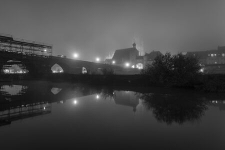 Night shot of the stone bridge in Regensburg with fogの写真素材