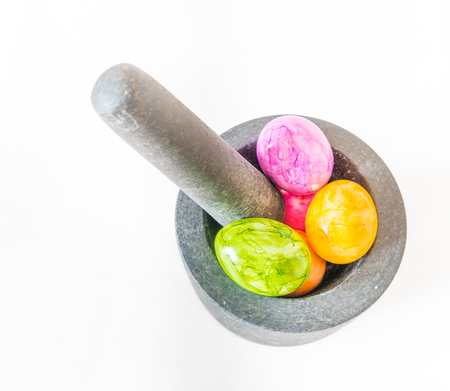Colorful Easter eggs in a granite mortar and white backgroundの写真素材
