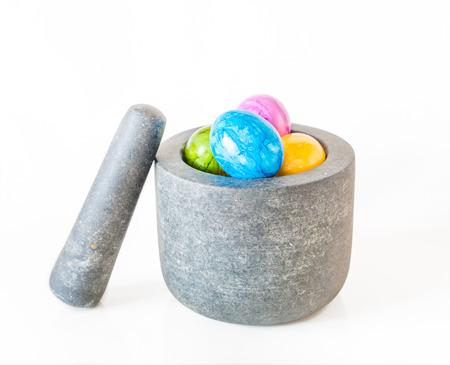 Colorful Easter eggs in a granite mortar and white backgroundの写真素材